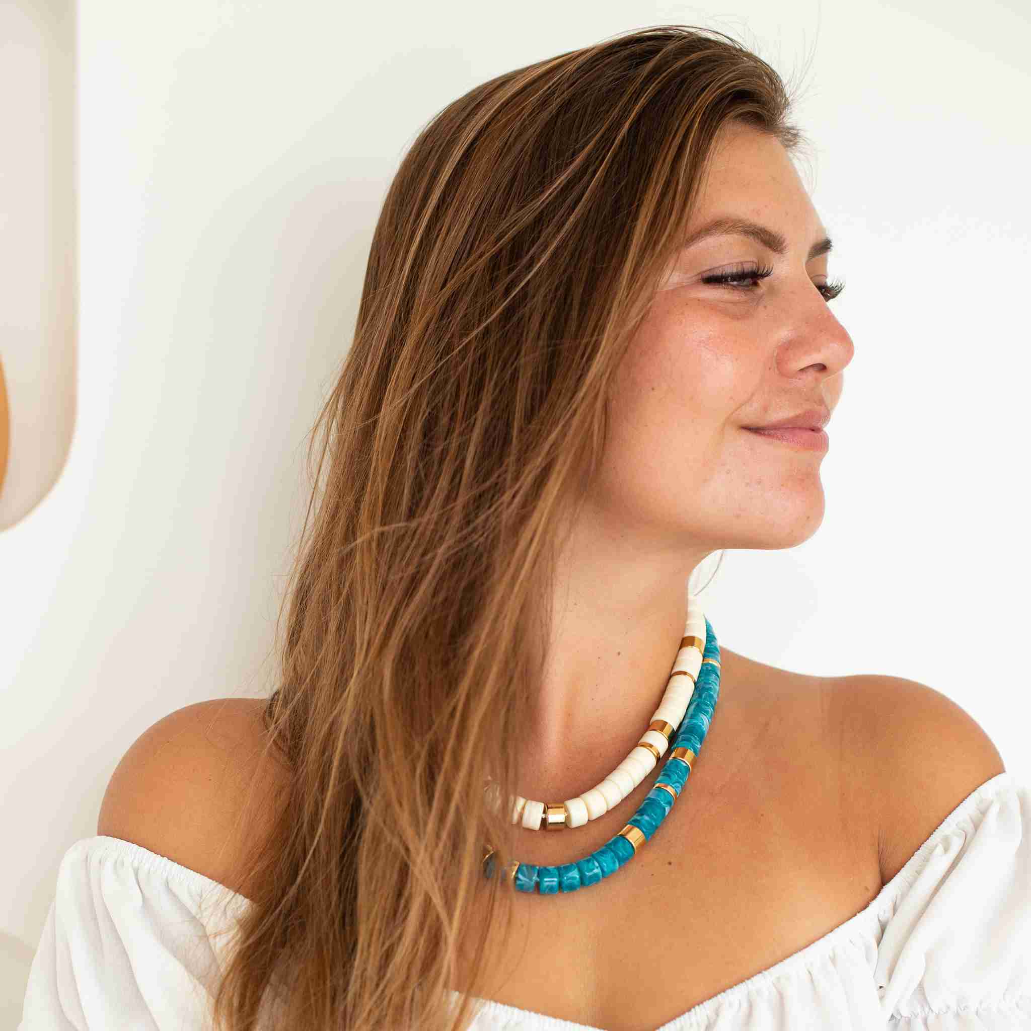 Description Le collier Praia Turquesa se distingue par ses perles bleu turquoise marbré, associées à des touches d’acier doré disposées de manière asymétrique. Une combinaison lumineuse et estivale qui évoque les eaux cristallines. Monté sur un cordon délicatement rehaussé d’un fil lurex, il capte la lumière et apporte une touche éclatante à la silhouette. Sa longueur réglable permet de le porter de différentes façons, plus court ou plus long selon l’envie. Le fermoir est délicatement gravé du logo Parabaya