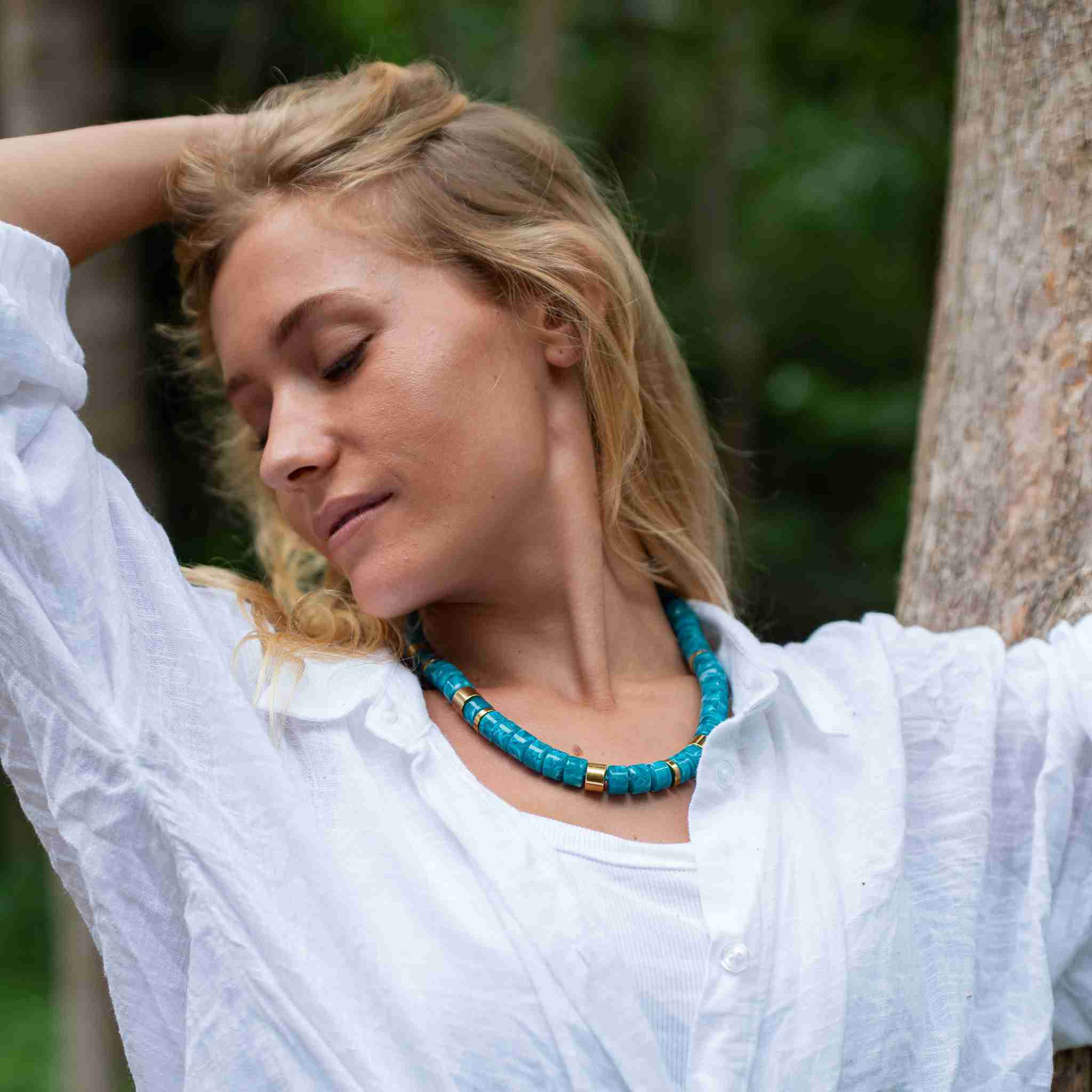 Description Le collier Praia Turquesa se distingue par ses perles bleu turquoise marbré, associées à des touches d’acier doré disposées de manière asymétrique. Une combinaison lumineuse et estivale qui évoque les eaux cristallines. Monté sur un cordon délicatement rehaussé d’un fil lurex, il capte la lumière et apporte une touche éclatante à la silhouette. Sa longueur réglable permet de le porter de différentes façons, plus court ou plus long selon l’envie. Le fermoir est délicatement gravé du logo Parabaya